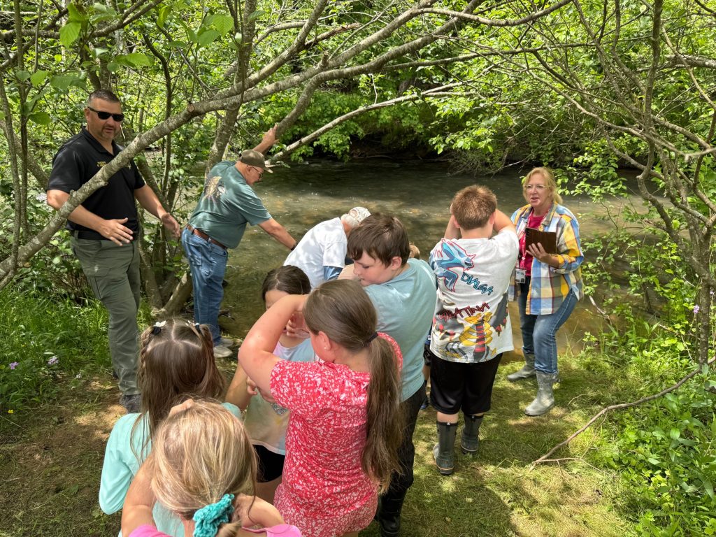 Students hiking to a stream to release trout raised in their classroom.